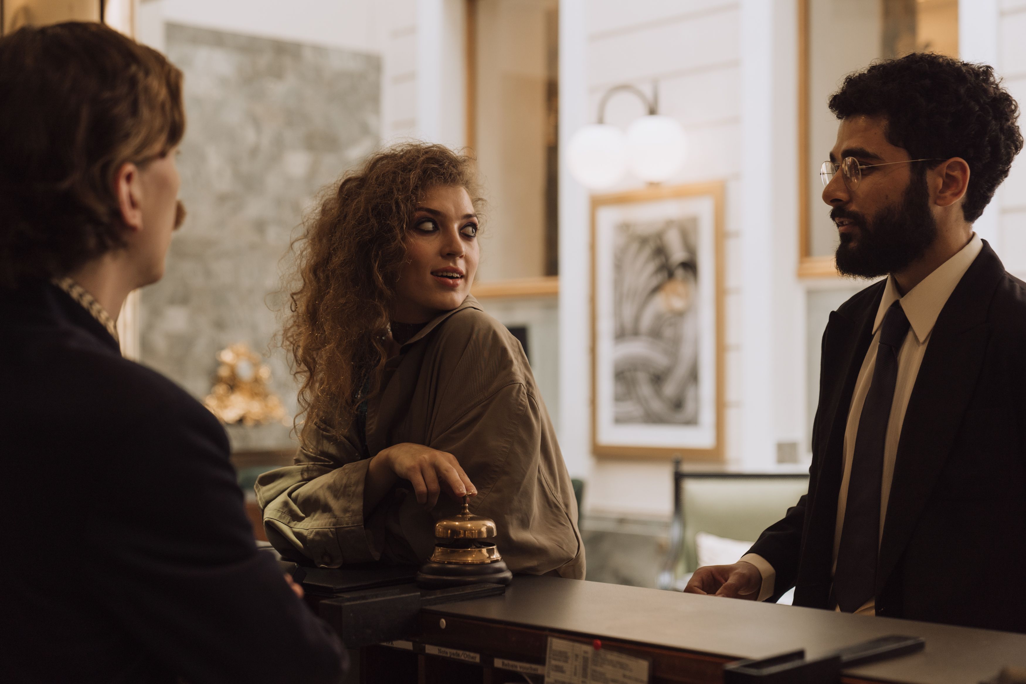 Guests interacting with staff at a luxurious hotel reception desk