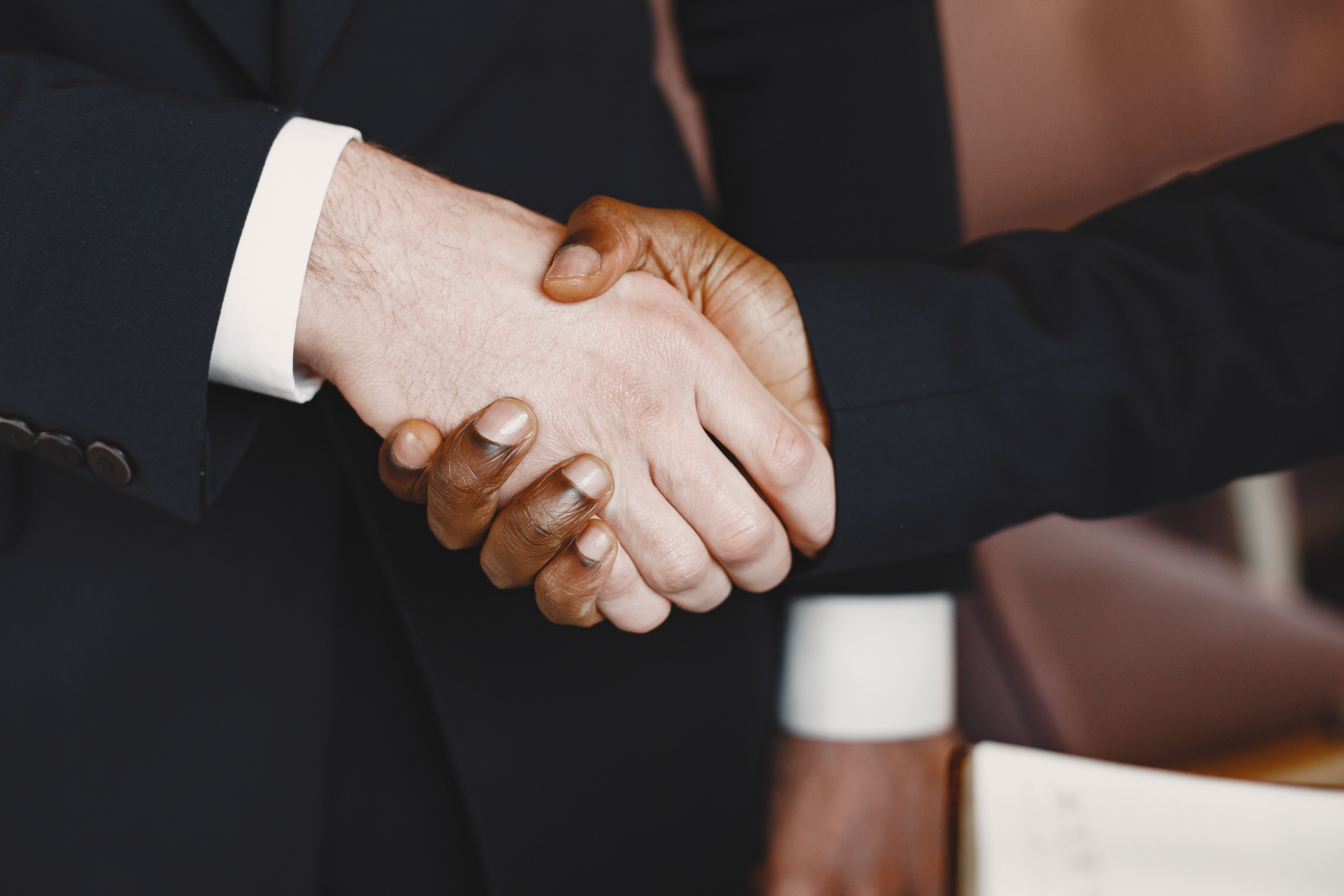 Close-up professional handshake symbolizing warm personal connection and trust