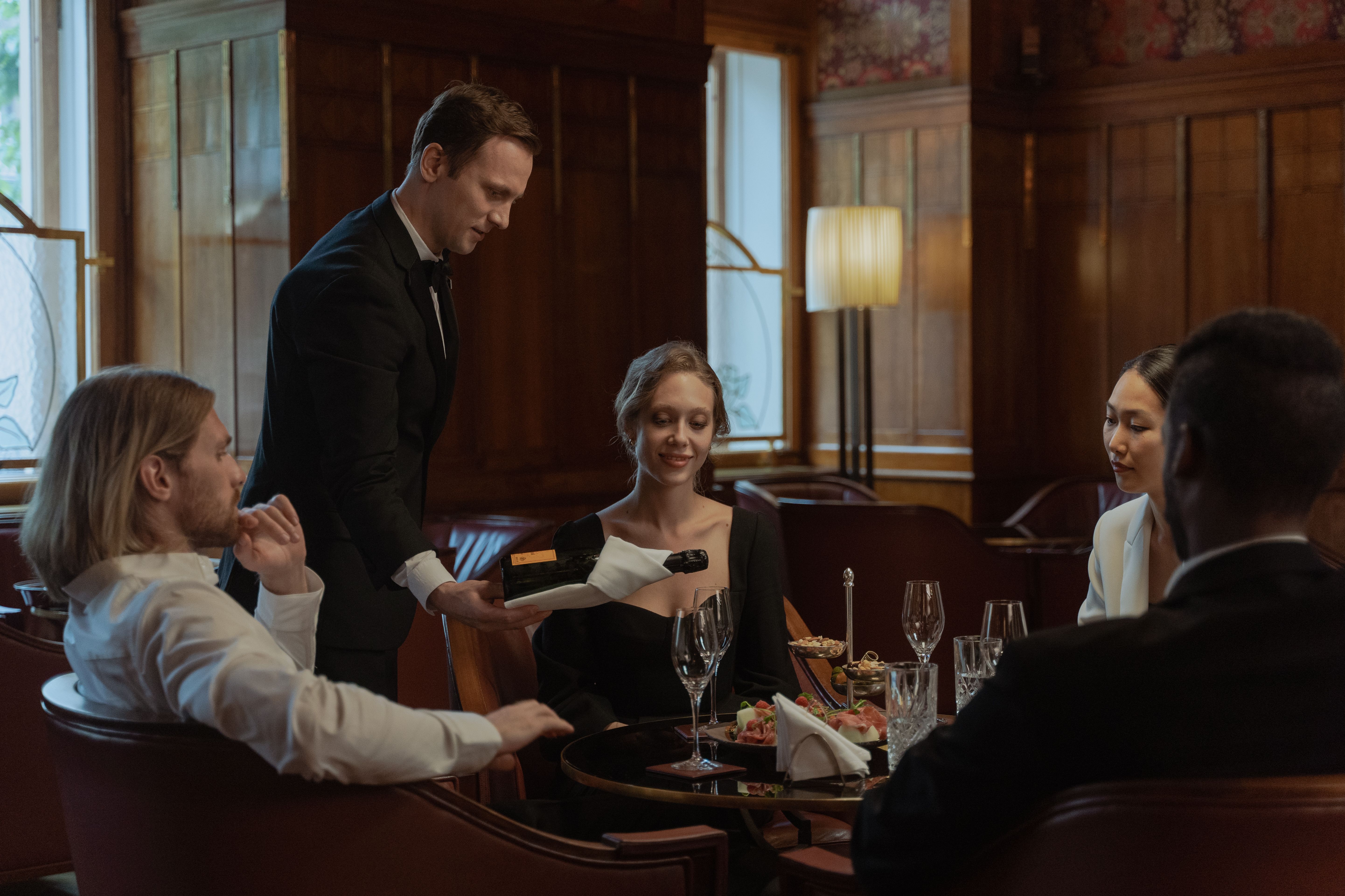 Waiter serving wine to guests during an elegant fine dining experience