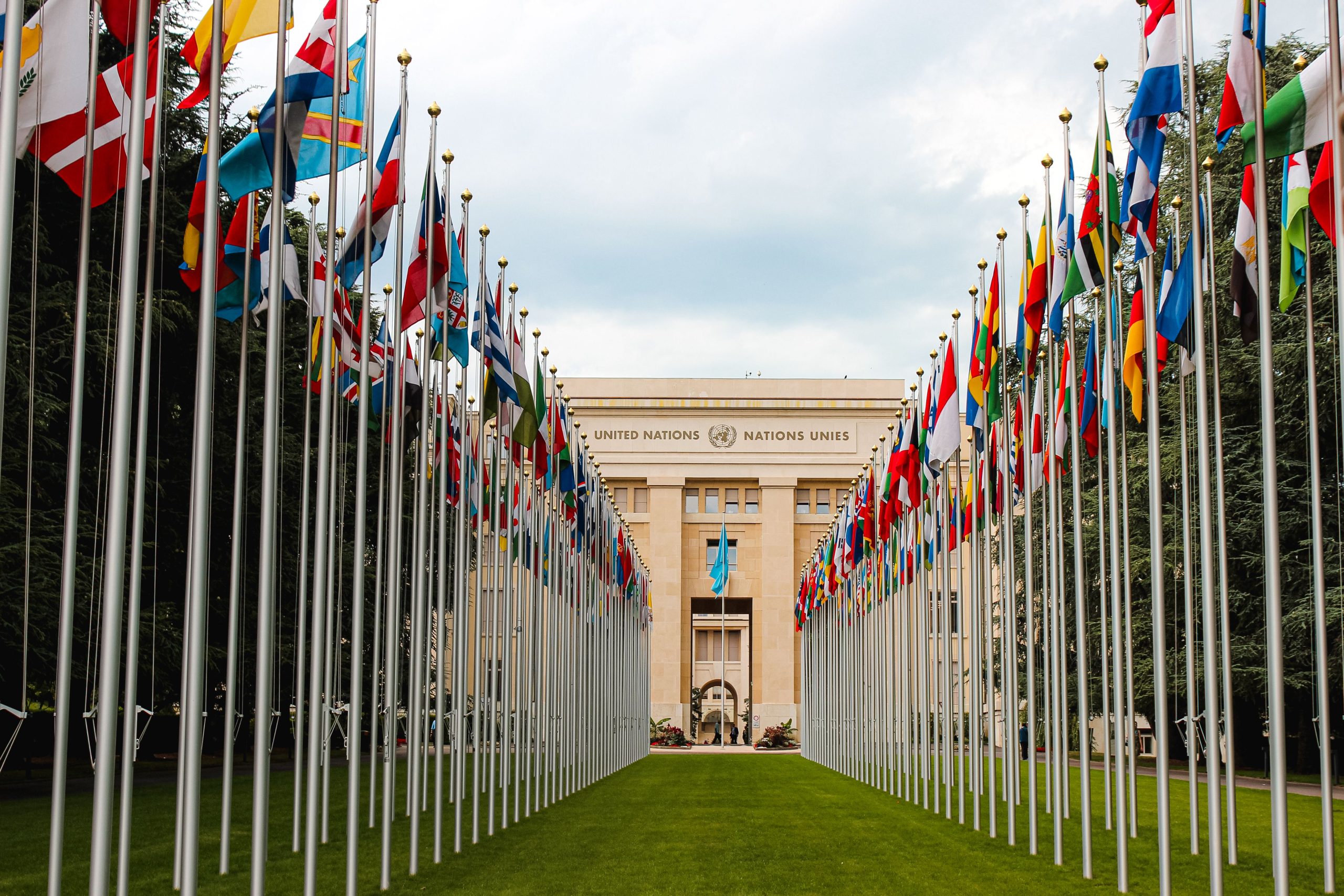 International flags outside the United Nations headquarters in Geneva, representing diplomacy and international relations.